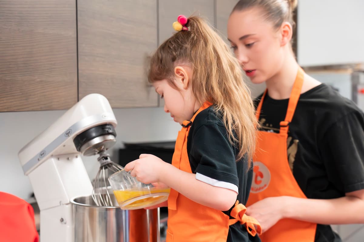 A child measuring ingredients into a mixing bowl