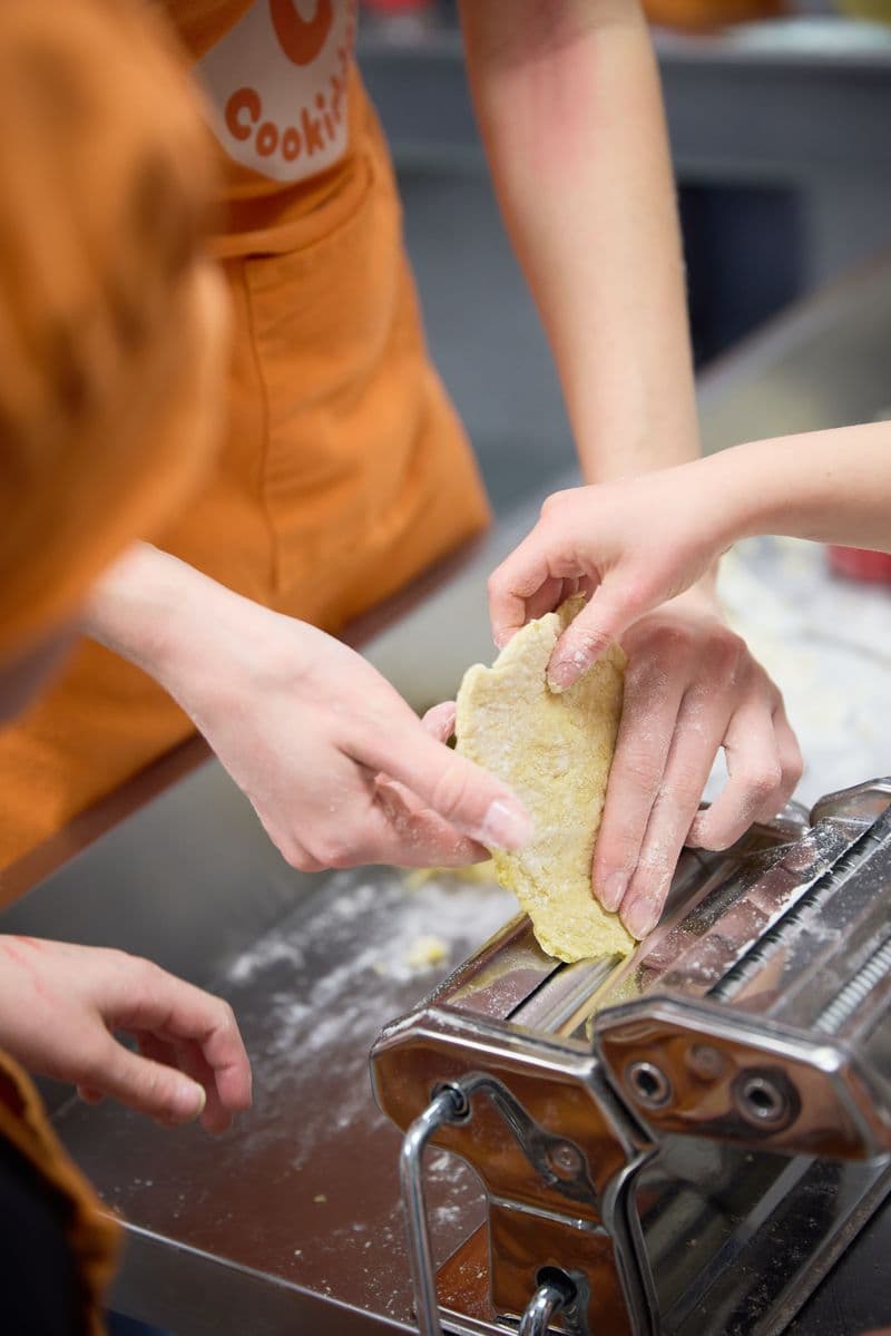 Hands rolling pasta dough